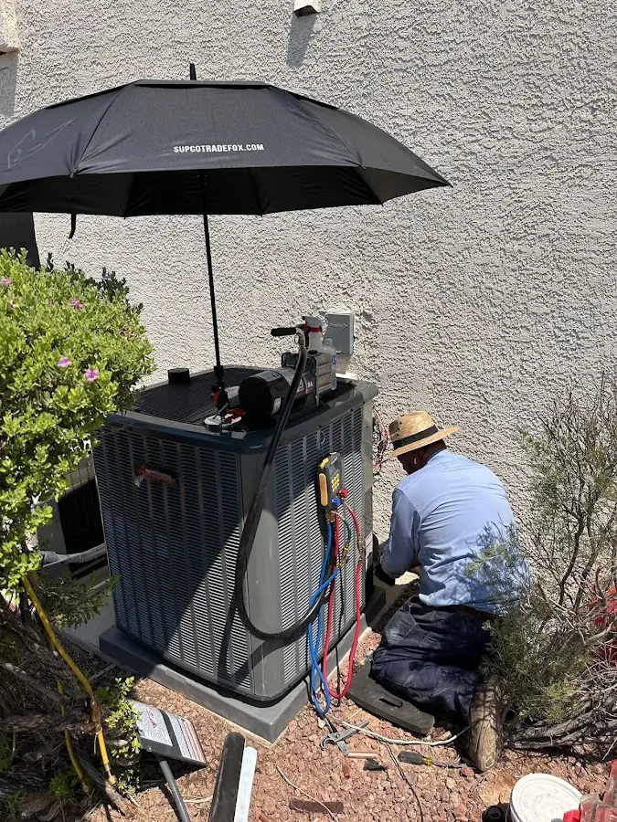 HVAC technician performing outdoor AC maintenance in Woodruff